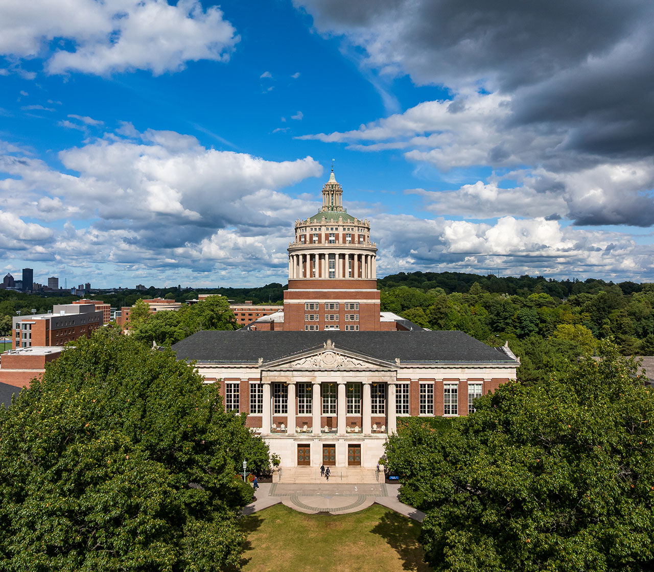 Rush Rhees library on a sunny day with clouds overhead.