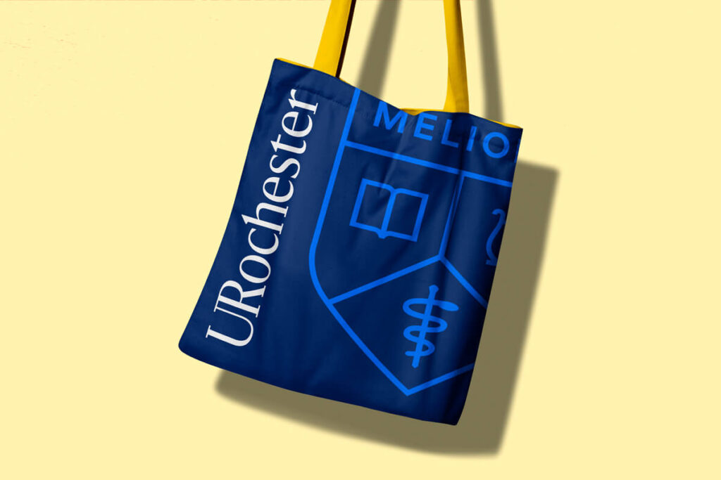 Blue tote bag featuring the University of Rochester logo prominently displayed on the front.